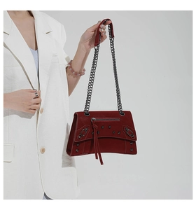 Close-up of a burgundy motorcycle style crossbody bag with rivets and chain strap