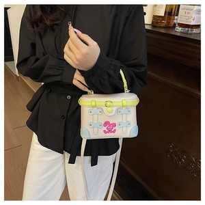 Close-up of contrast box bag featuring pink rabbit print and green handle detail
