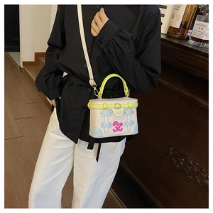 Detail view of contrast color box bag with neon handles and cute bunny patch decoration
