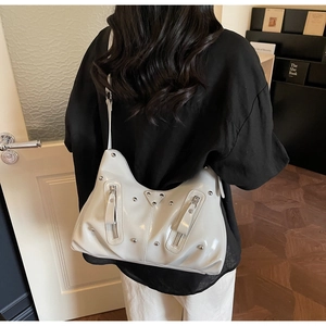 Détail du sac fourre-tout en cuir verni blanc crème avec clous argentés et double fermeture