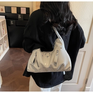 Détail du sac hobo en cuir verni blanc crème avec rivets argentés et garnitures en métal