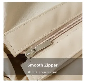 Dettaglio della cerniera in metallo liscia e trama in nylon della borsa intrecciata beige
