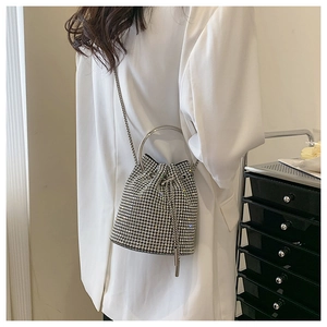 Close-up of sparkling silver rhinestone bucket bag with drawstring and metal chain