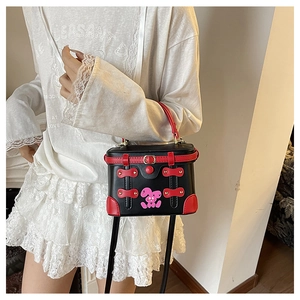 Detail view of the black and red vintage box bag with pink cartoon bunny and metal buckle