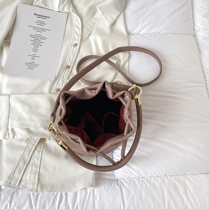 Pink lychee grain leather bucket bag with gold hardware and spacious red fabric interior