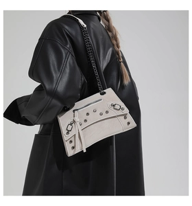 Detail showing vintage motorcycle style bag with metal rivets and black chain strap