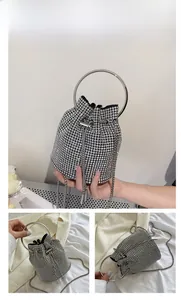 Close-up of silver rhinestone bucket bag showing metal ring handle and tassel drawstring