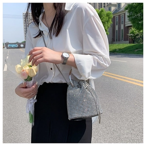 Silver rhinestone bucket bag with shiny crystals and metal chain strap on model