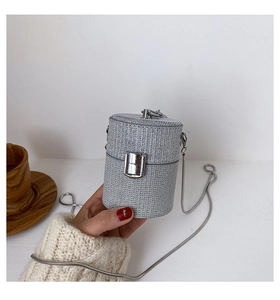 Detail of silver sequined cylinder mini bag with metallic chain and clasp closure