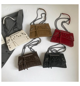 Close-up of studded motorcycle style crossbody bags in five colors with chain straps
