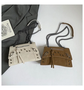 Detail view of retro trapezoid crossbody bags with metal studs and long fringe tassels