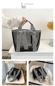 Detail of small black mesh tote bag featuring a decorative bow and striped handle straps