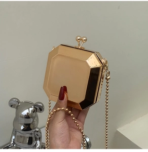 Detail of golden octagonal mirrored clutch bag with vintage kiss-lock and bead chain