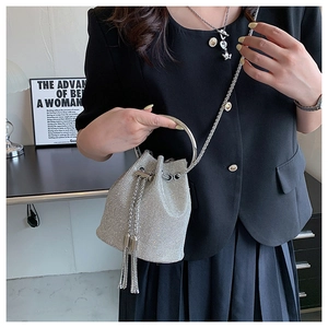 Detailed view of silver rhinestone bucket bag with tassel fringes and ring handle