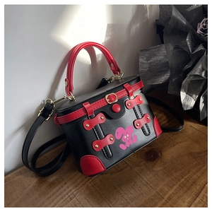 Detail of contrast box bag with pink rabbit print and metallic gold buckle closure