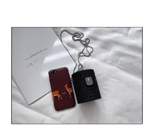 Detailed size comparison of a mini black sequin cylinder bag with silver chain strap