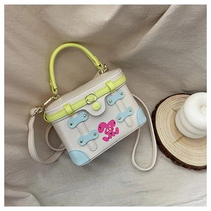 Detail of square mini handbag featuring cartoon rabbit print and neon green handle