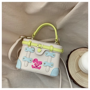 Mini cream box bag with neon green handle and pink cartoon rabbit print detail