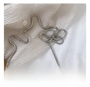 Detail of silver snake bone chain featuring a dense woven metal texture and polished finish