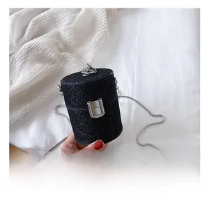 Detail shot of black sequin cylinder bag with silver metal handle and press lock closure
