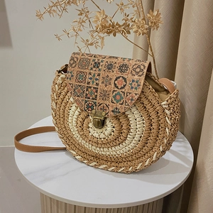 Borsa a tracolla tonda in paglia intrecciata con patta in sughero floreale