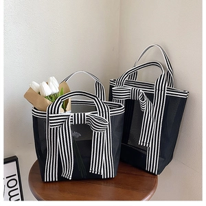 Macro detail of black mesh tote bags with striped ribbons and elegant bow accents