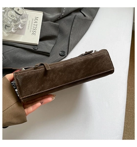 Detailed shot of dark coffee rivet crossbody bag with vintage leather texture and silver chain