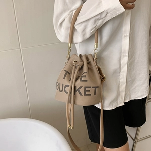 Detail of light brown leather bucket bag with drawstrings and The Bucket print