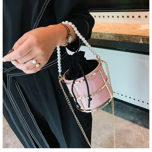 Borsa a secchiello rosa in ferro con manico di perle e tracolla a catena dorata