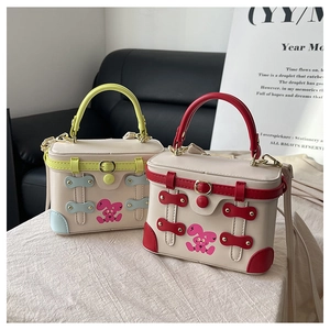 Close-up of contrast box bags with trendy bunny print and vintage leather buckles