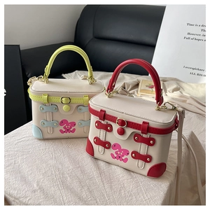 Detail of colorful box bags with cartoon rabbit prints and retro buckle straps