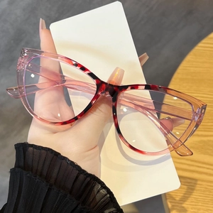 Detail of hand-held cat-eye glasses frame with pink to deep red gradient leopard pattern