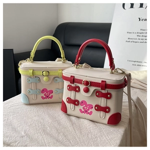 Detail of color-block box bags with pink rabbit prints and metal buckle closures