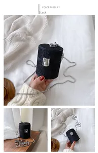 Detail of a mini black glitter cylinder bag with silver chain and metallic buckle