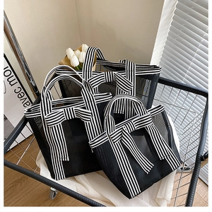 Detailed set of three black mesh tote bags with striped handles and bow decoration