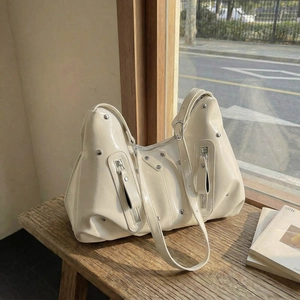 Sac hobo chic en cuir verni crème avec rivets argentés et fermetures éclair style motard