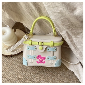 Detail of cartoon bunny print on a cream box bag with blue trim and yellow handle