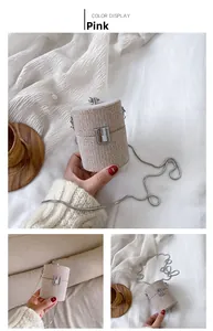 Close-up of pink woven cylindrical mini bag with silver chain strap and metal clasp