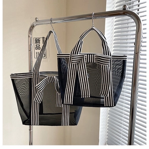 Detail view of black mesh tote bag set with striped ribbon bows and dual handles