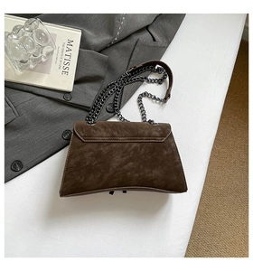 Detailed view of brown retro flap bag with metallic chain strap and textured finish