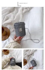 Detail of grey mini cylinder rhinestone bag with silver chain strap and metal buckle
