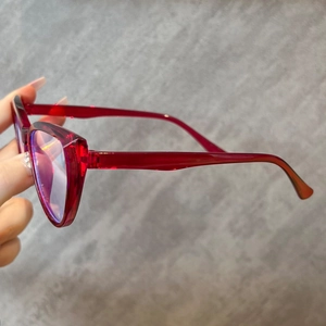 Detail view of transparent red cat-eye frames with anti-blue light reflective lenses