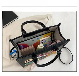 Interior view of black tote bag showing spacious capacity for tablets and wallets