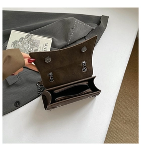 Internal view of brown matte chain bag showing zipper compartment and magnetic buckles