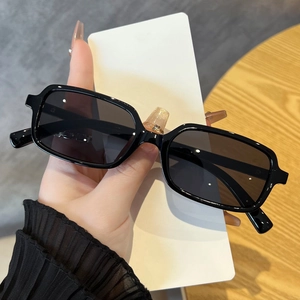 Close-up of black rectangular sunglasses with glossy full-rim frames on a white card