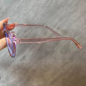 Detail of pink transparent cat-eye glasses frame with sleek temples and clear finish