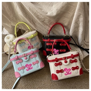 Detail of four colorful box bags with rabbit prints and metal stud decorative straps