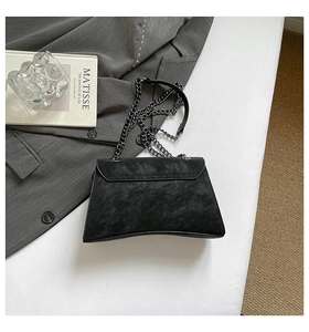 Detail of black riveted chain crossbody bag with vintage matte leather texture