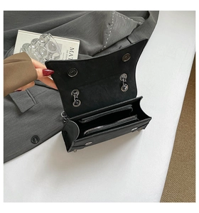 Interior detail of black leather crossbody bag showing main compartment and silver zipper
