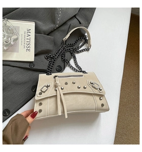 Detailed view of beige rivet crossbody bag with matte PU leather and tassel zippers